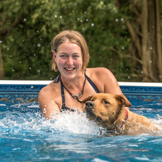 Kara Meyers and dog playing in the pool for dog daycare and boarding at Canine Athletics